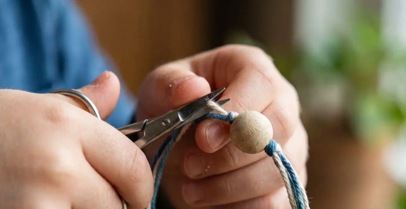 Gros plan sur des mains d'enfant perfectionnant les finitions d'un objet artisanal avec attention aux détails